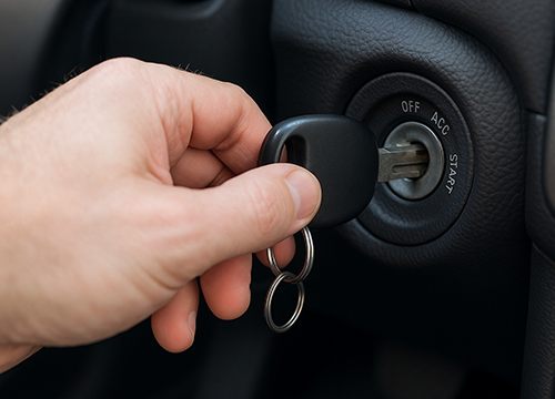 Hand pulling car key from ignition switch