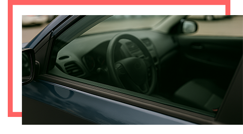 View of a parked car’s interior through closed side window with no keys inside